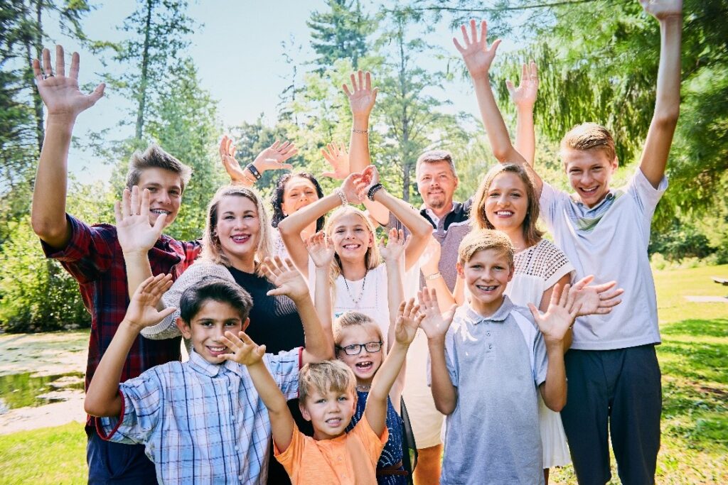 Group of people waving outdoors.