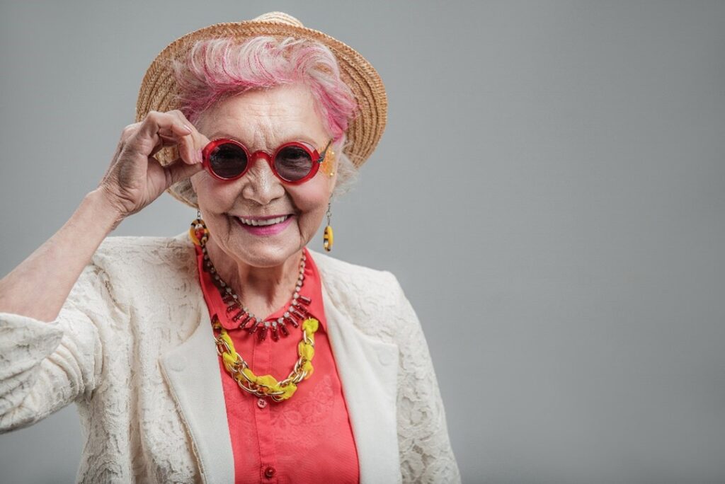Stylish elder in pink hair.