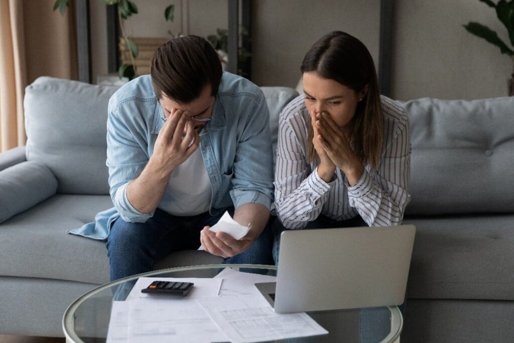 Stressed couple reviewing bills.