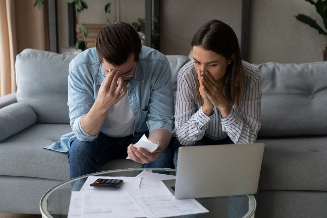 Stressed couple reviewing bills.
